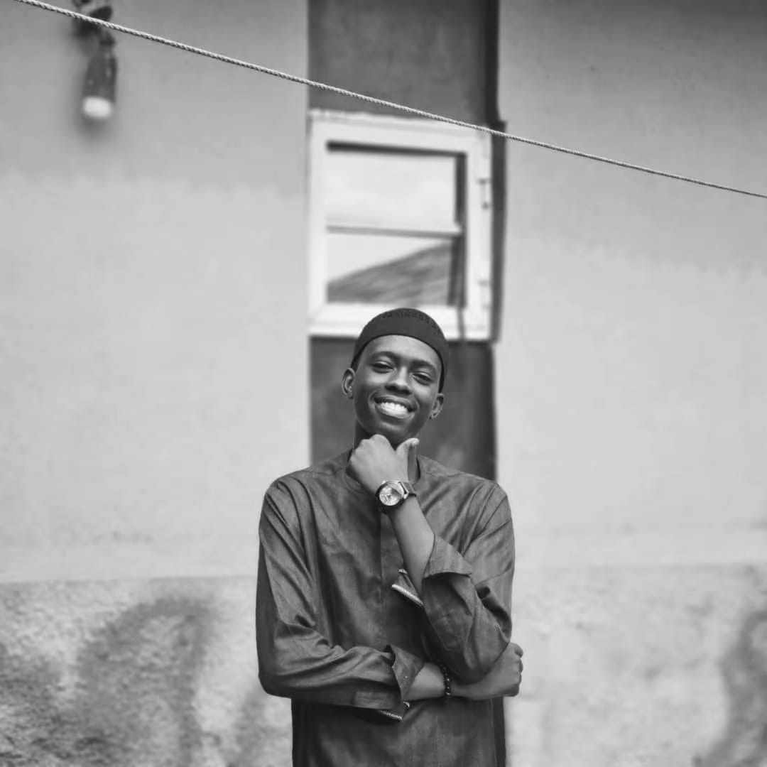 Black and white portrait of Fawaz Olayinka smiling outdoors