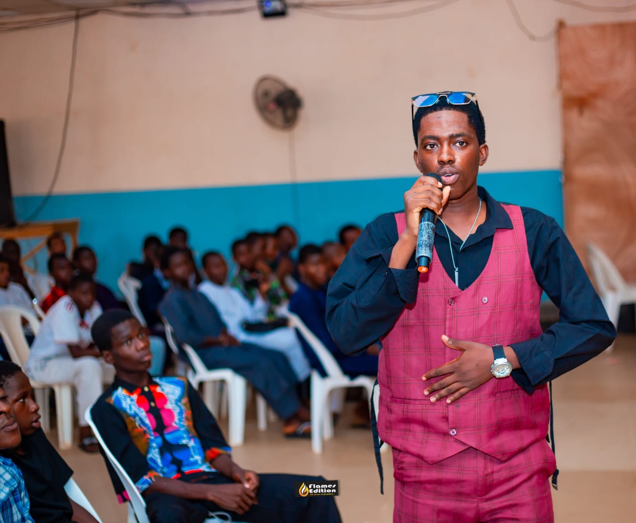 Fawaz Olayinka speaking with a microphone at an FHG training event
