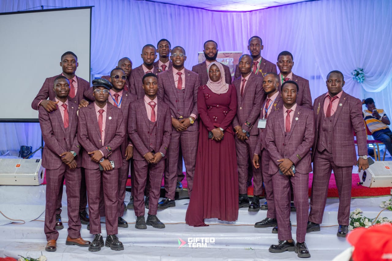 Fawaz Olayinka with his FHG team leaders on stage in matching suits
